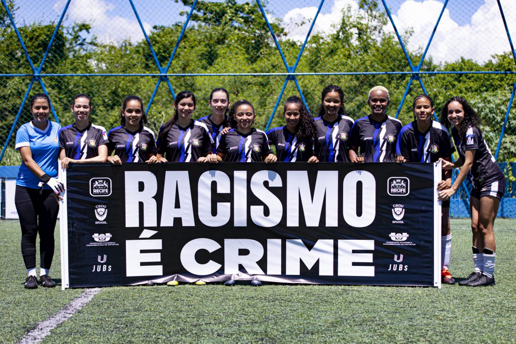 Atletas fazem ação com faixa contra racismo no JUBs